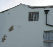 Damaged render on wall being repaired by P & AS Hayselden Decorators Barnsley